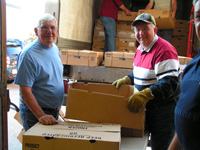 Retirees Pulling Frozen Turkey Boxes from Delivery Truck